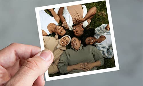 Hand holding sticker of friends laughing